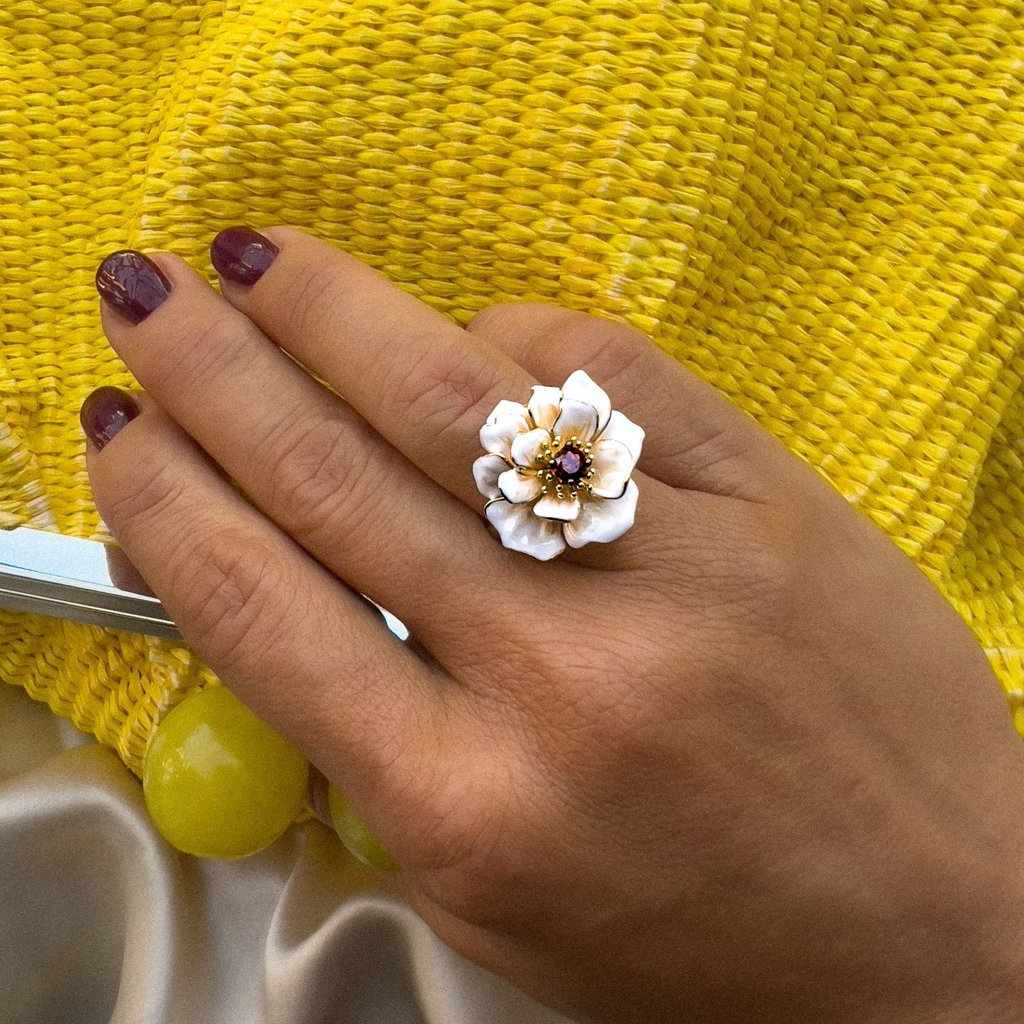 Hvit Magnolia Blomst Ring med granat cubic zirkonia, båret som et elegant slv smykke til både hverdagsbruk og spesielle anledninger. Sølv ring med forgylling, emalje og stener.