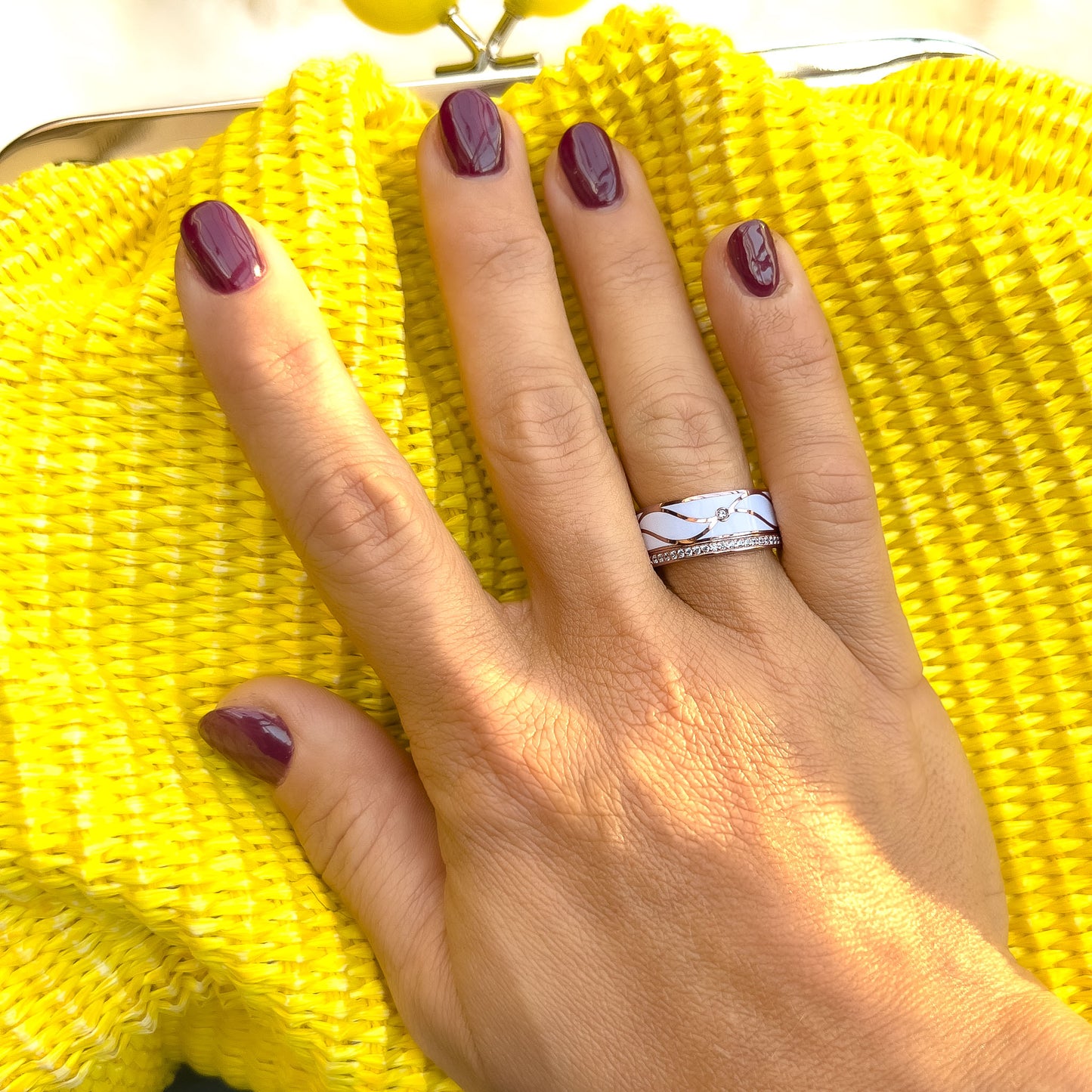 Hvit Sjokolade Drøm Sølv Ring i rosé forgylt sølv med cubic zirkonia og emalje detaljer, båret som et unikt og sofistikert tilbehør. Et sølv smykke med forgylling, emalje og stener.