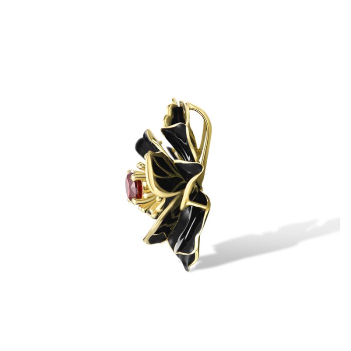 Sølv anheng i gullbelagt sterlingsølv med svart emalje og granat cubic zirkonia, inspirert av magnoliaens dramatiske eleganse og tidløse design. Blomst anheng i forgylt sølv med edelstener.