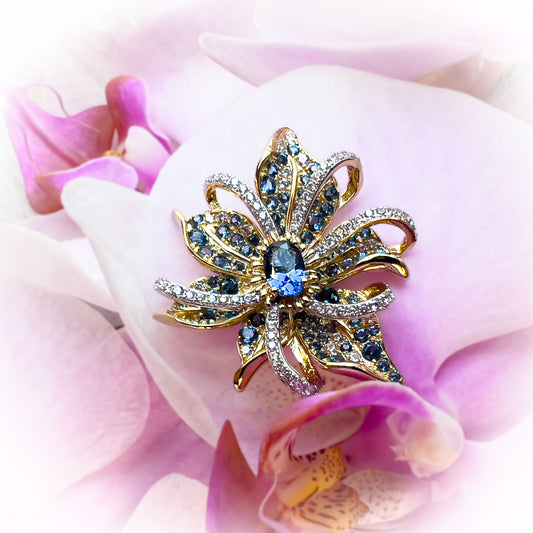 Nærbilde av Stjerne Blomst Anheng i forgylt sterlingsølv med detaljerte blå spineller og gnistrende hvite cubic zirkonia. Gullbelagt smykke i sterling sølv med edelstener.